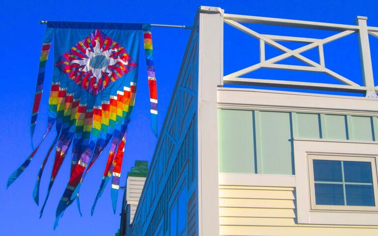 A rainbow colored banner hangs from a building