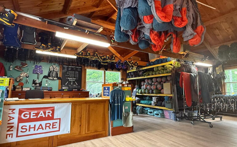 A room is full of camping gear and there's a wooden counter.