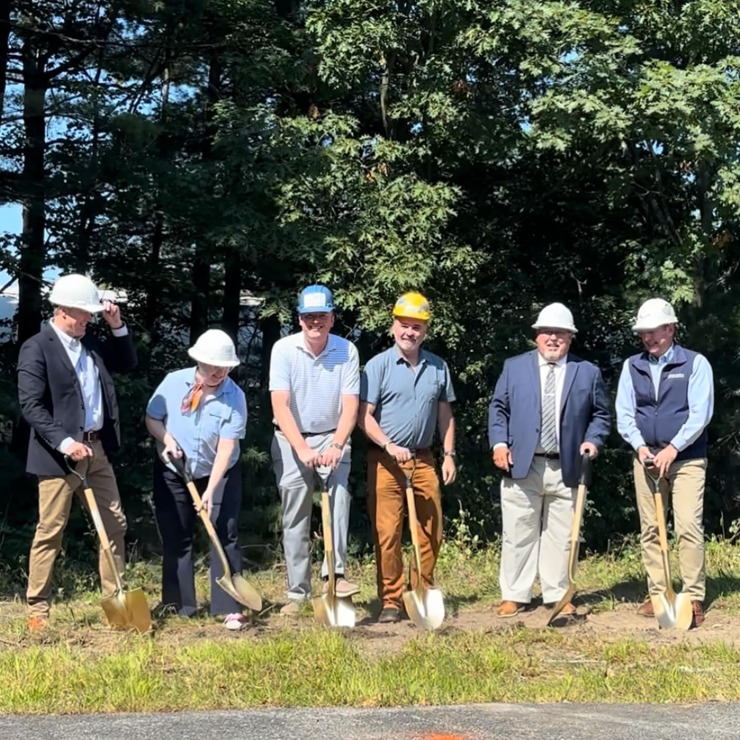People pose in a line with shovels.