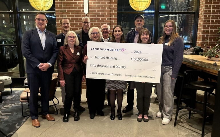 A group of people pose with an oversize check.