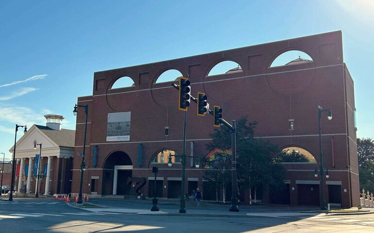An exterior view of a small building next to a larger building.