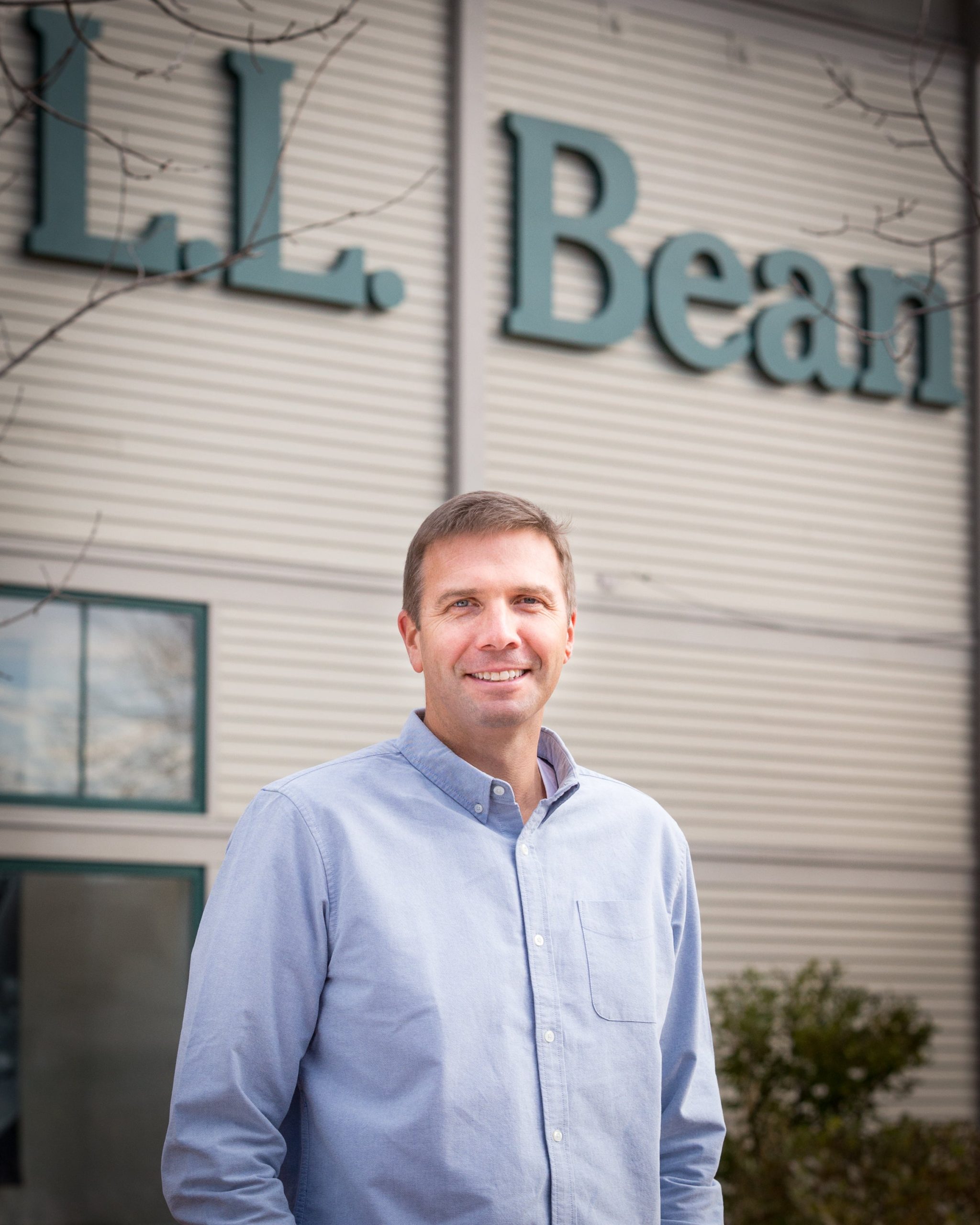 Photo of Steve Smith, president and CEO of L.L.Bean, in front of L.L. Bean building showing company logo