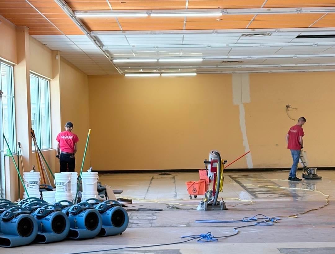 An interior view shows people buffing a floor.