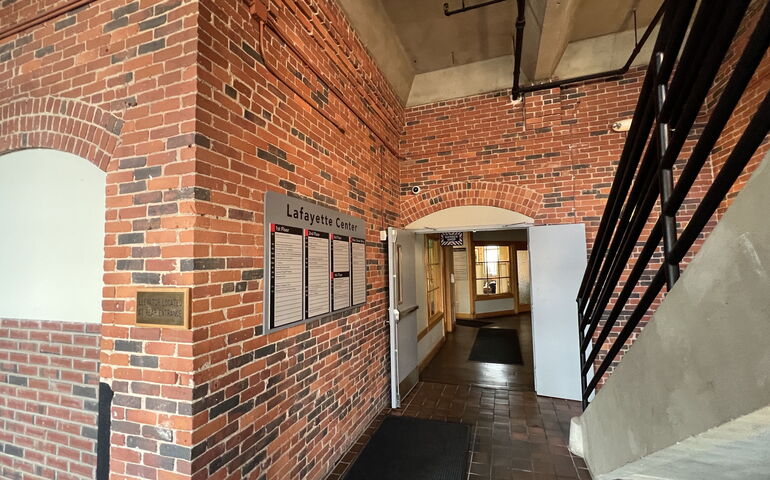 The interior of a building has brick walls and a concrete stair.