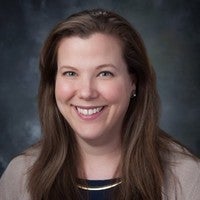 women in a tan sweater and black shirt.