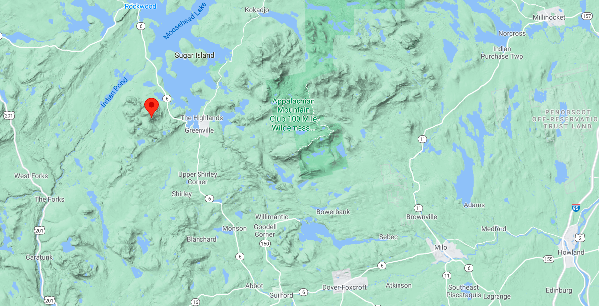 a terrain map shows a location marker on a mountain that is northwest of greenville next to Moosehead Lake