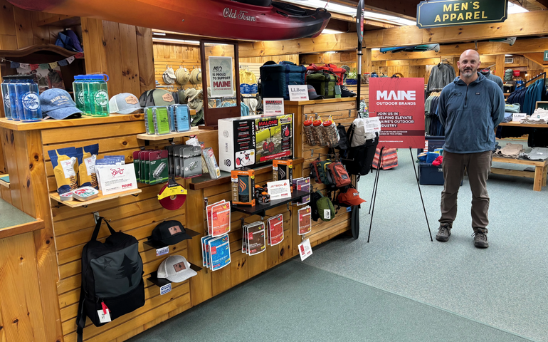 A person stands in a room with a display of products.