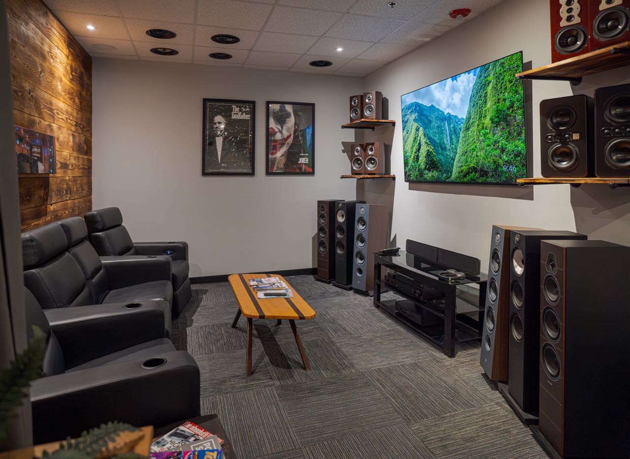 A room has screens, seating and speakers.