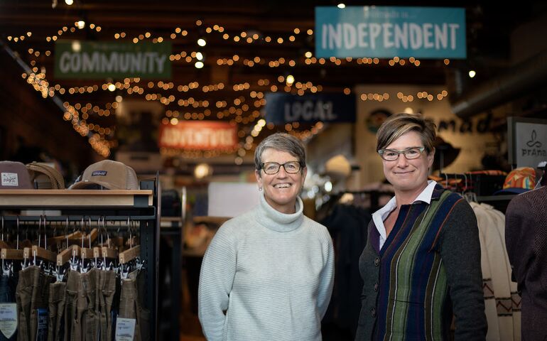 two women standing in front of clothing displays
