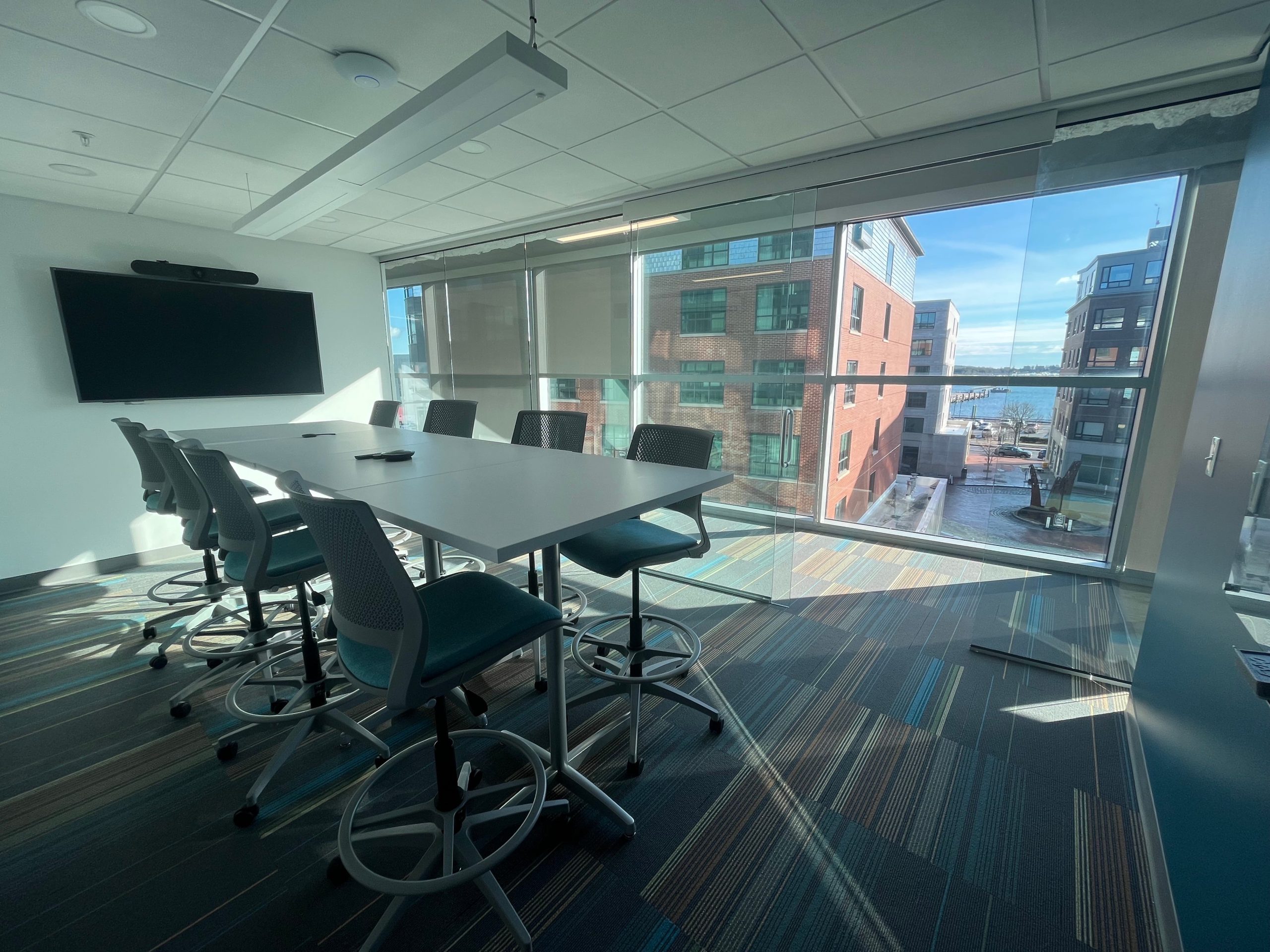 An office interior includes a table, chairs and windows.