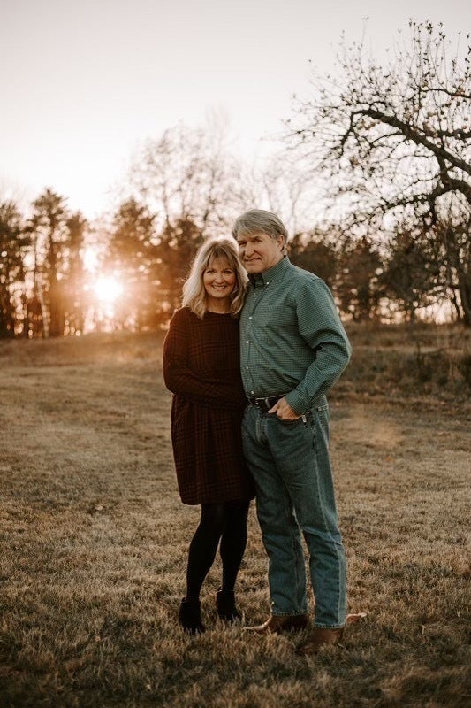 Peggy and Eric Cianchette standing outside in front of trees