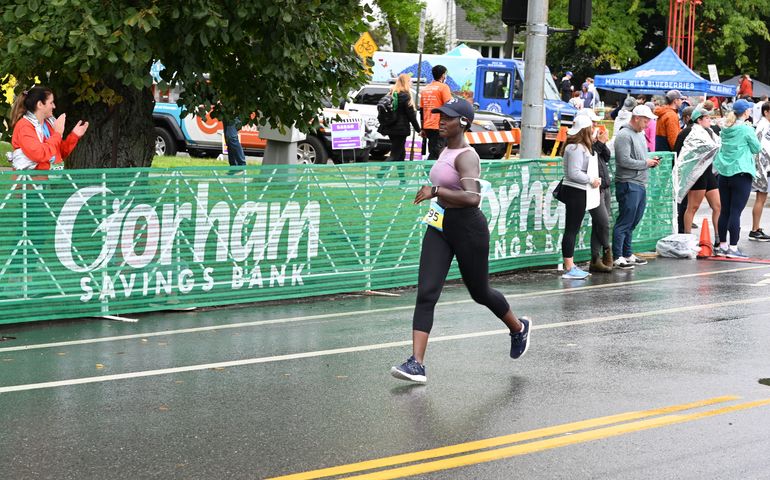 Marathon runners in action, with people watching