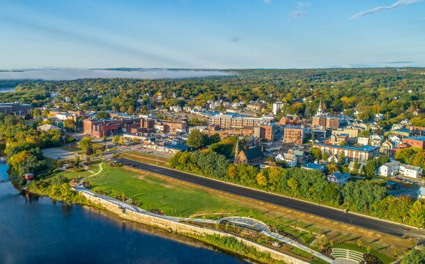 An aerial view shows buildings, a river and a bridge.