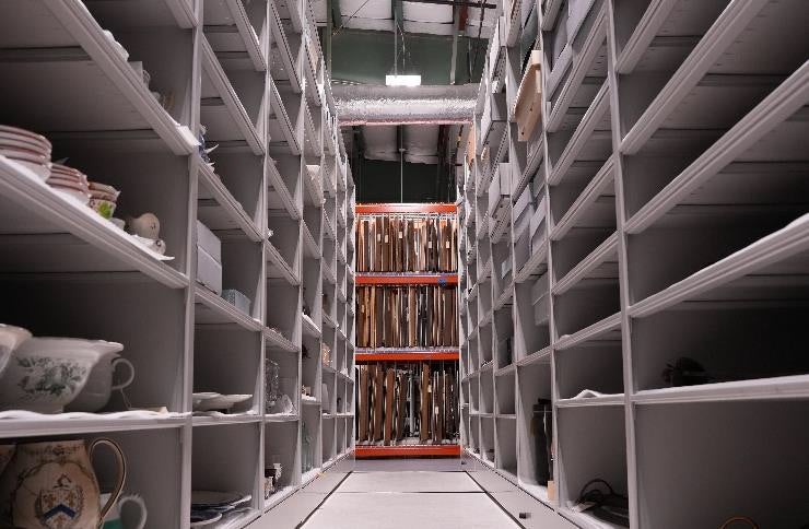 Shelves stand in an aisle.