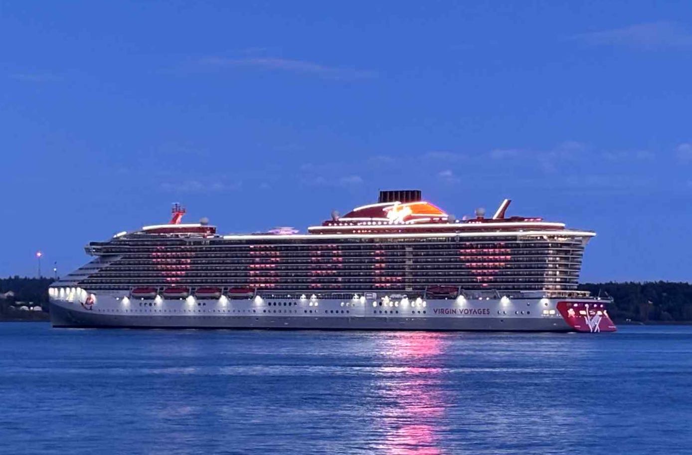 A ship is lit up at dusk.