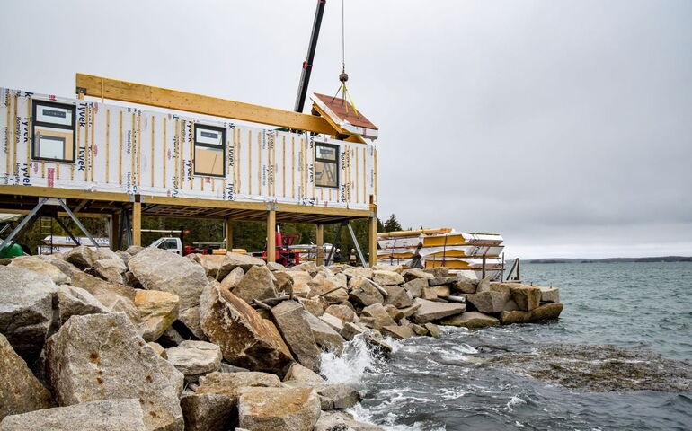 building under construction on rocks with water