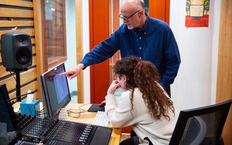 Two people look at a computer screen.