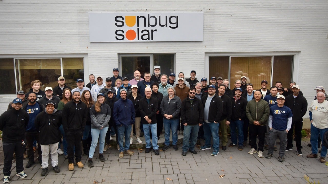 group of people lined up with sign and building