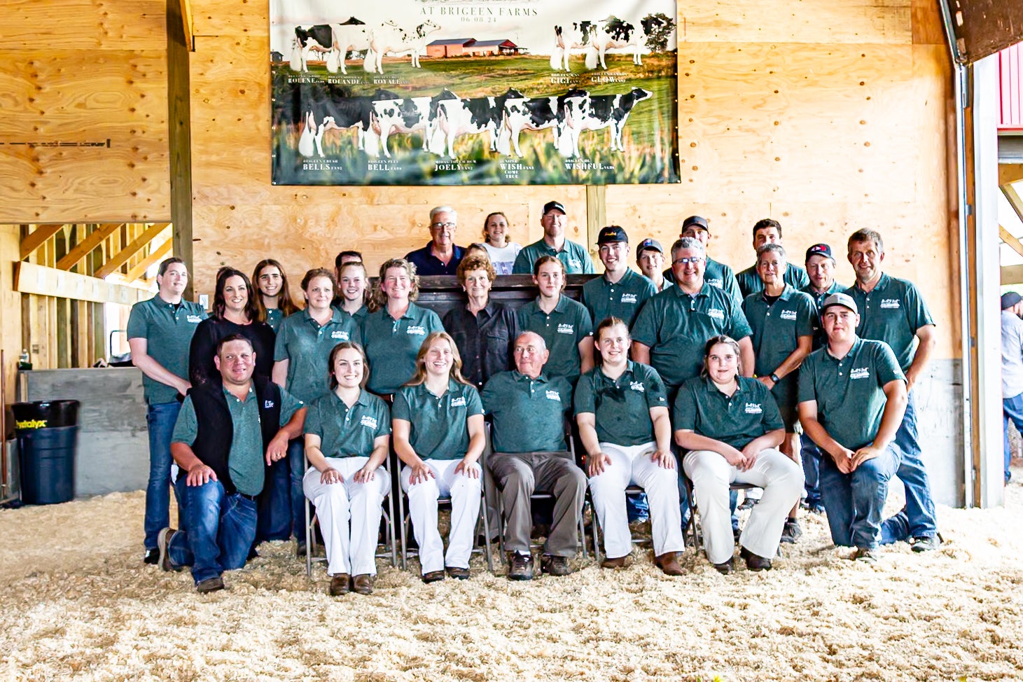 A group of people at Brigeen Farms poses in a barn.