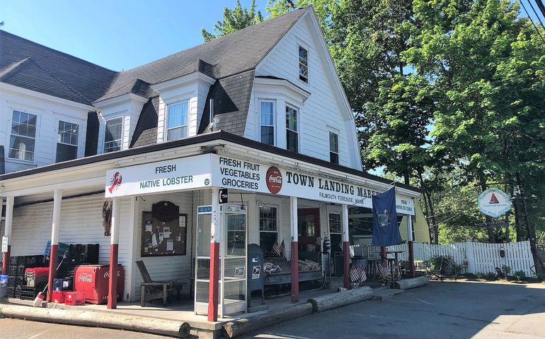 exterior of store in white building with hipped roof