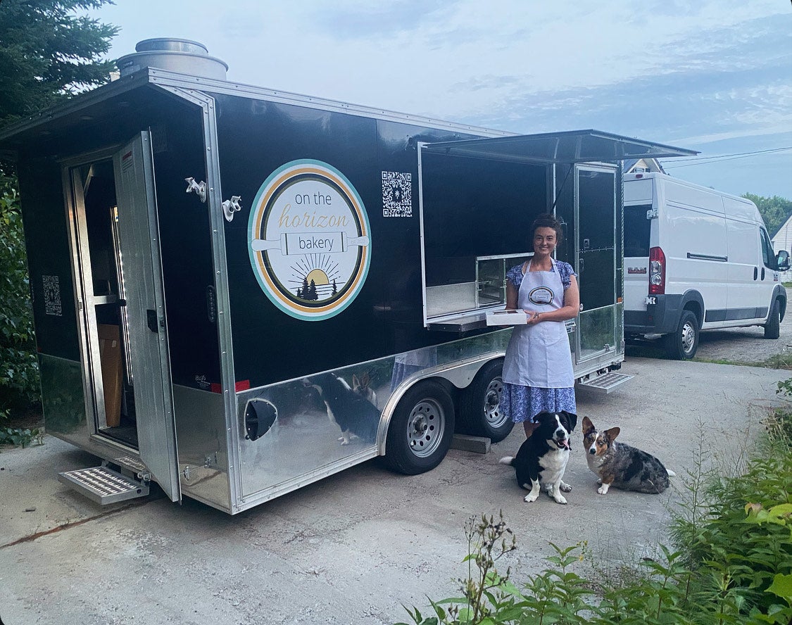 The owners stands outside of her bakery truck.