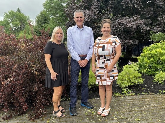 Three people pose at the Maine Arts Academy.