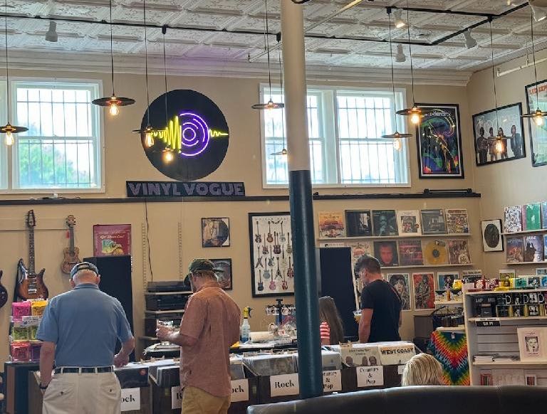 At Vinyl Vogue, people look at records on display racks.