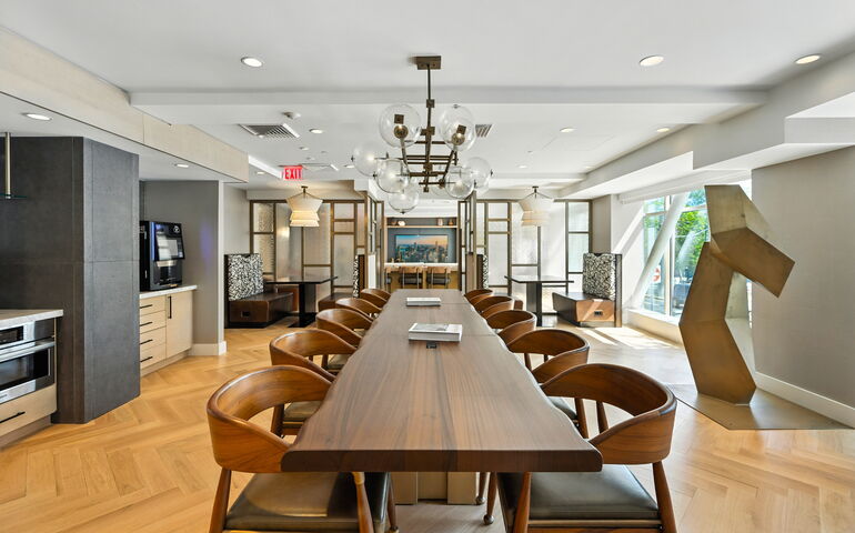 A kitchen has a long table and chairs.