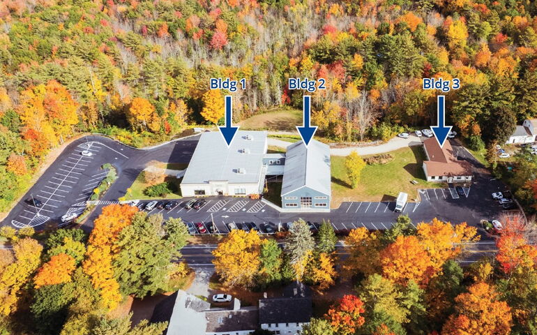 An aerial view shows buildings, parking lots and trees with lettering overlaid.