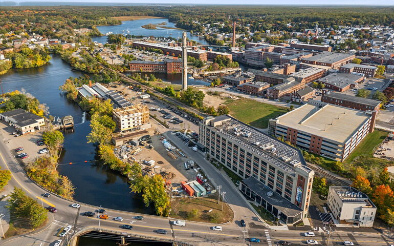 An aerial view shows buildings and a river.