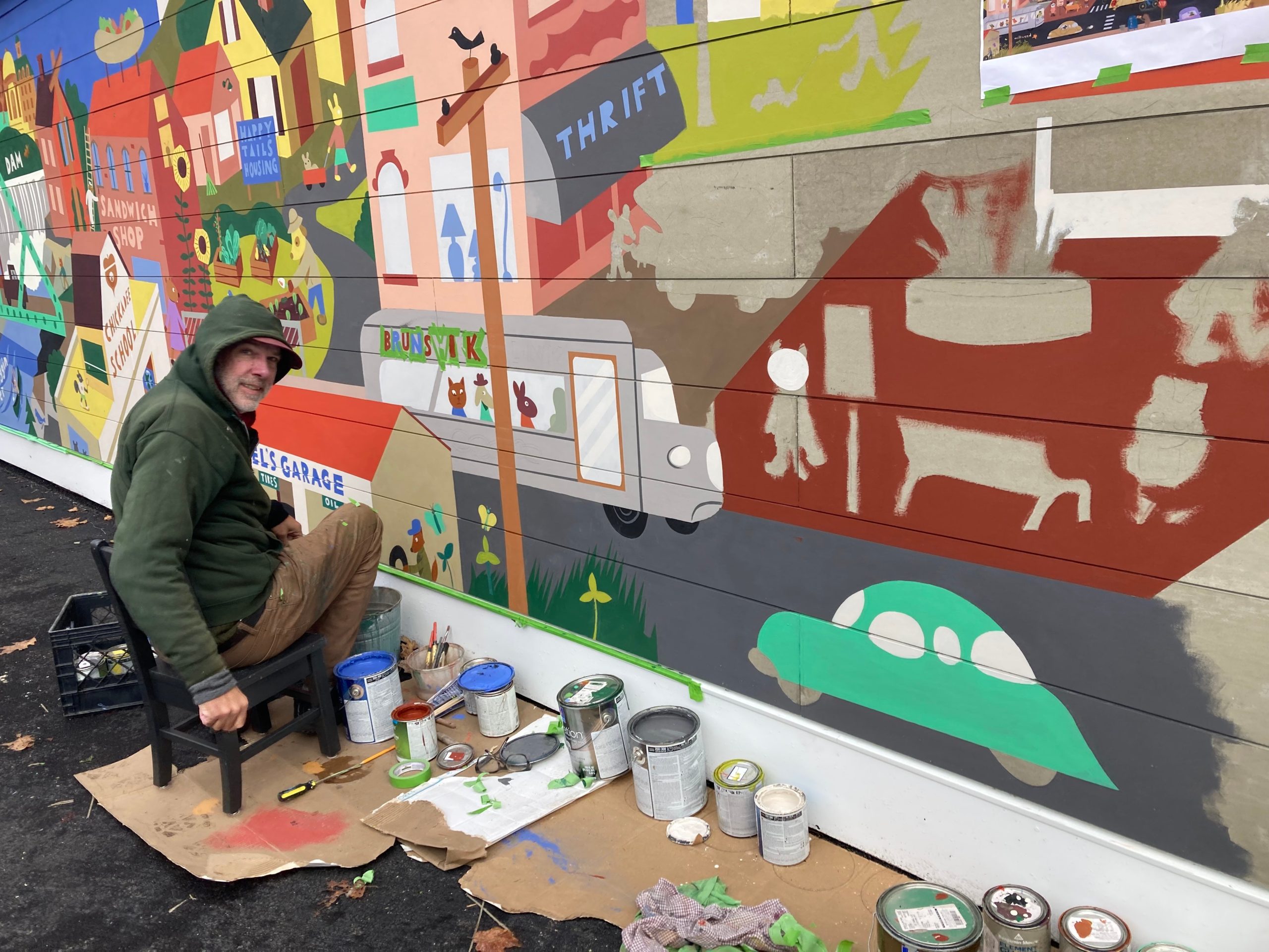 man painting a mural on a building