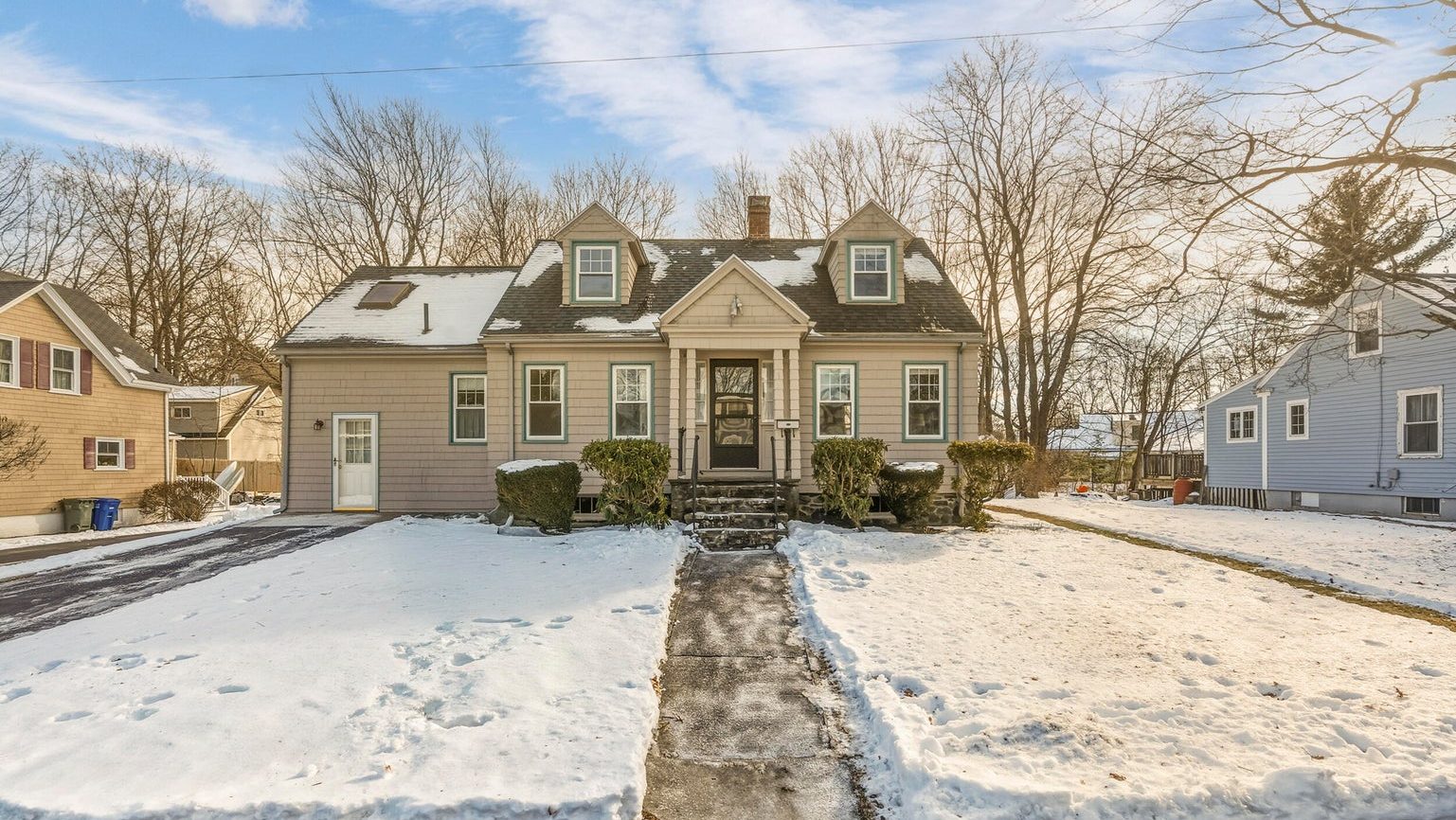 A house has a snowy lawn.