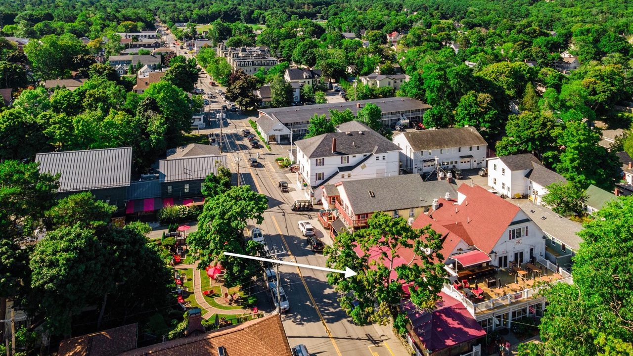 An aerial view shows buildings and an arrow overlaid the photo.