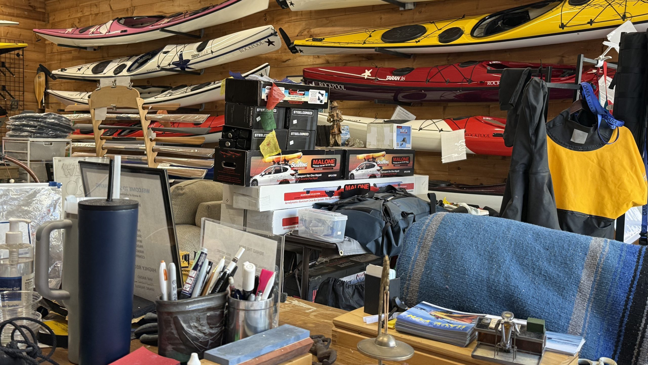 A shop is full of kayaks and gear.