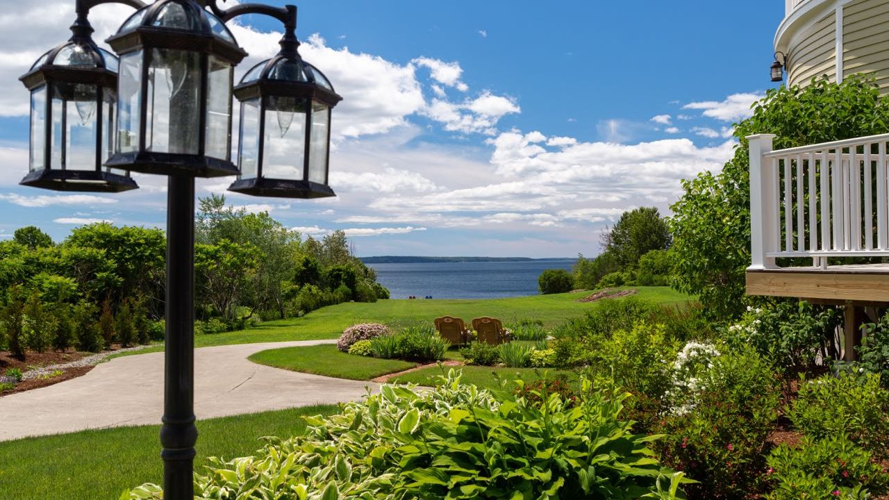 A garden and walkway have a lampost.