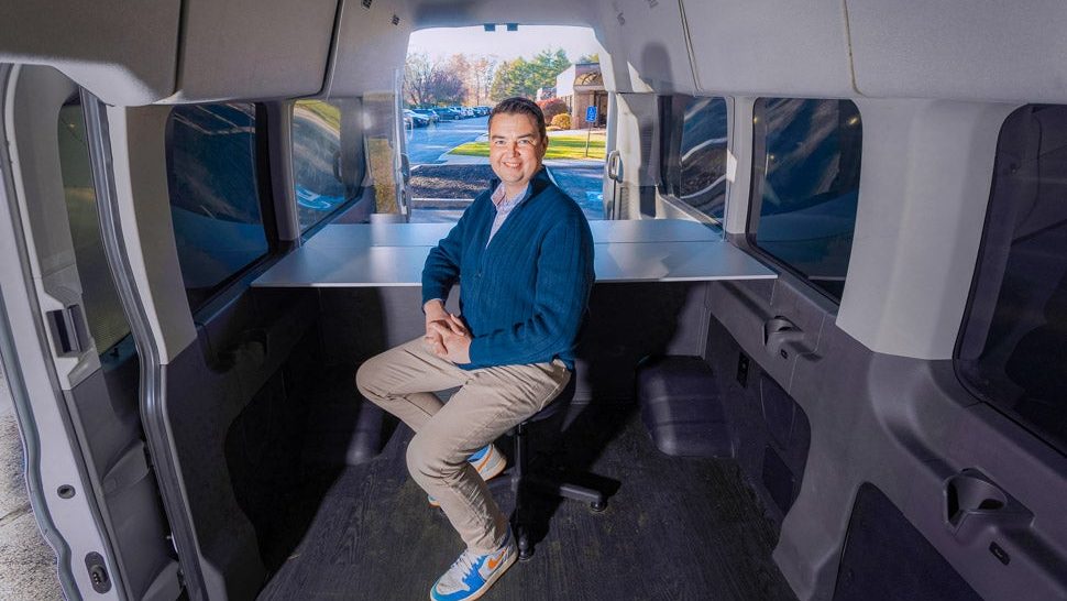 A person sits inside a van.