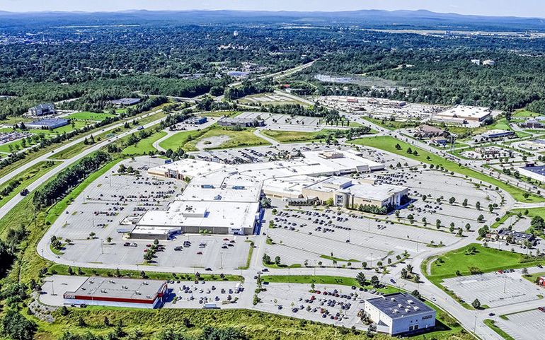 An aerial view shows buildings and a parking lot.