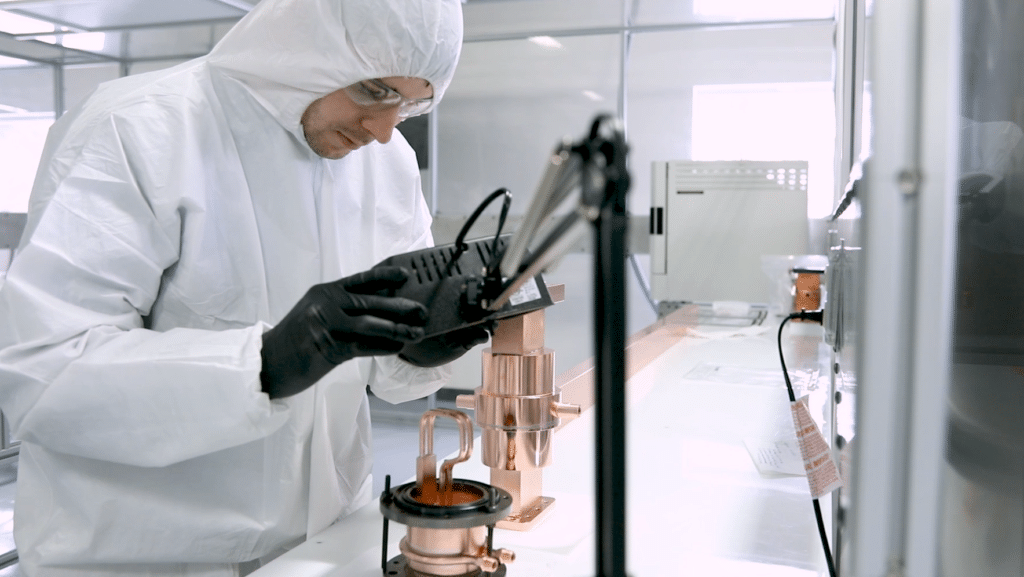A person wearing protective gear works with equipment.