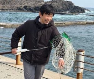 A person is by the water and holds a net.