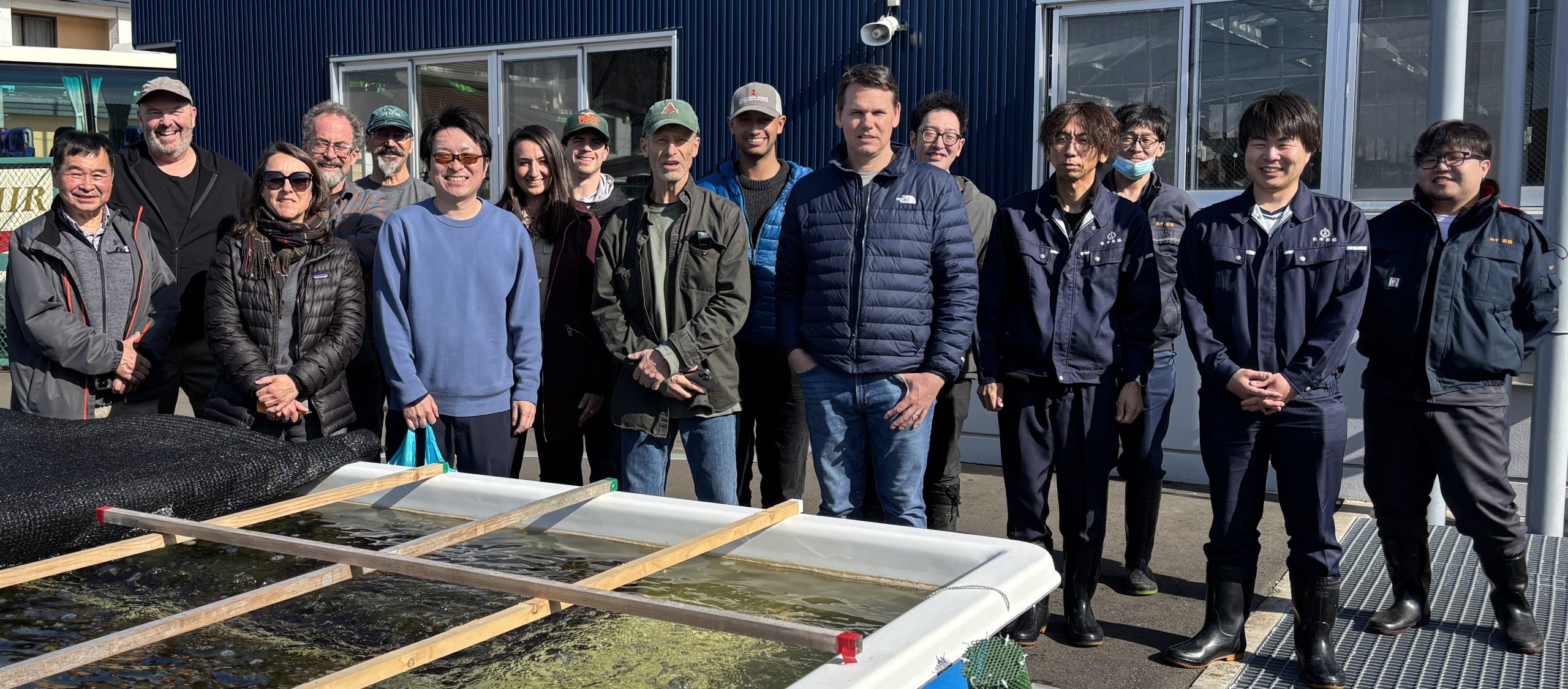 A group stands behind a tank.