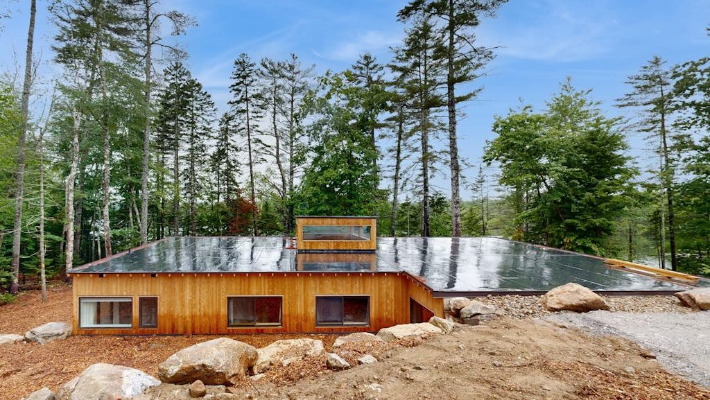 A wooden house is low with a flat roof.
