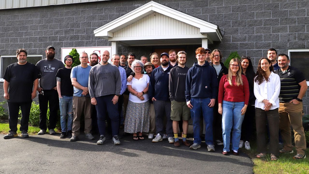 A group of people pose in front of a building.