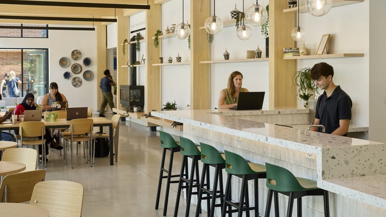A cafe has tables, chairs and a counter.