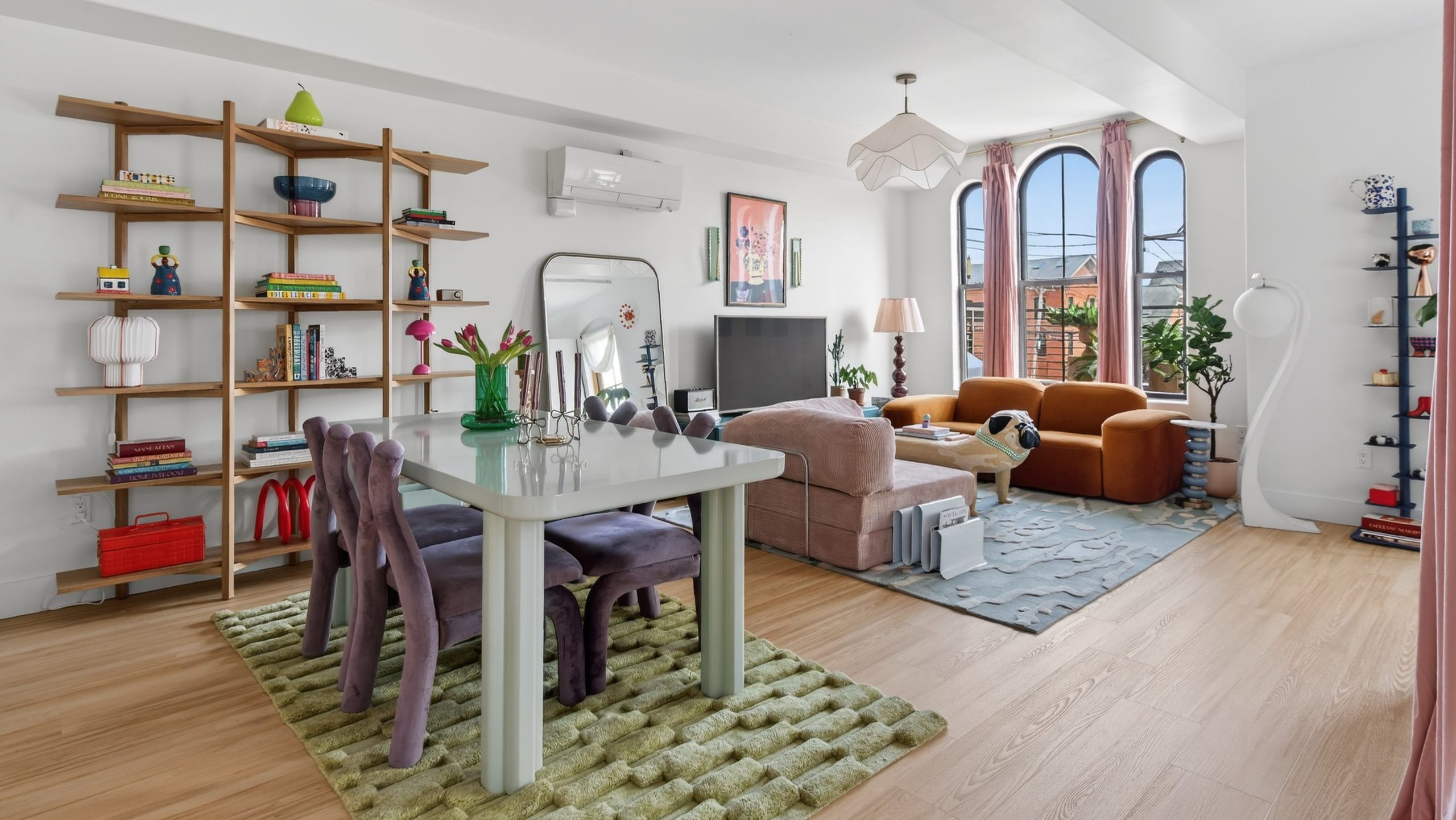 A room has colorful objects and arched windows.